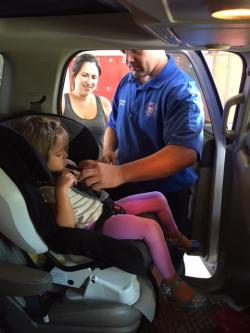 Public Safety Volunteer installing car seat.