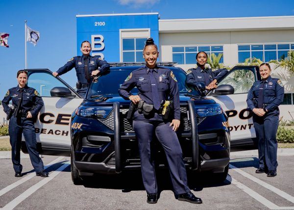 Several Officers Take a Group Photo in and Around a Police Cruiser